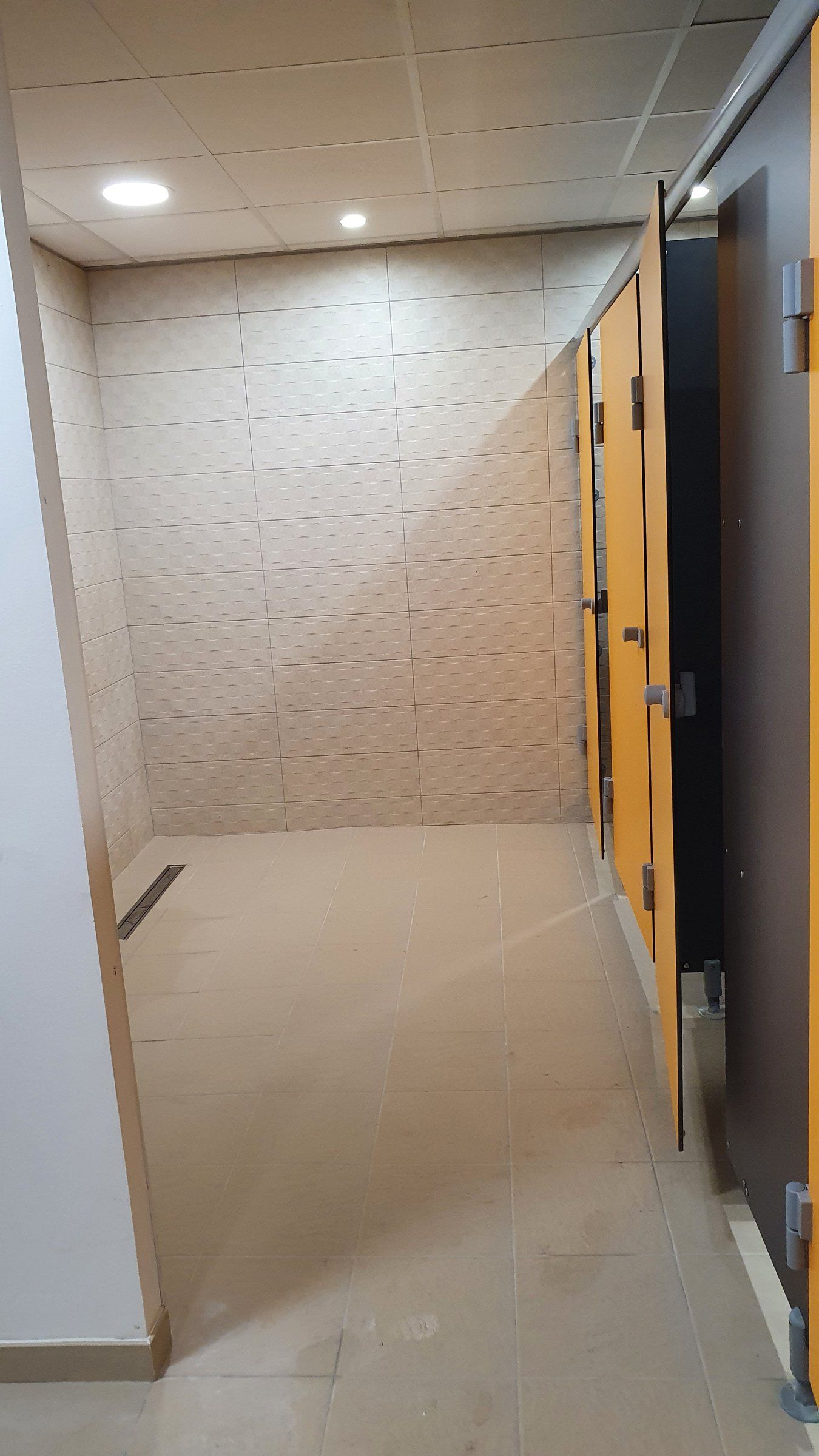 La même zone en juillet 2020 : faïence neuve, cabines et caniveau de douche