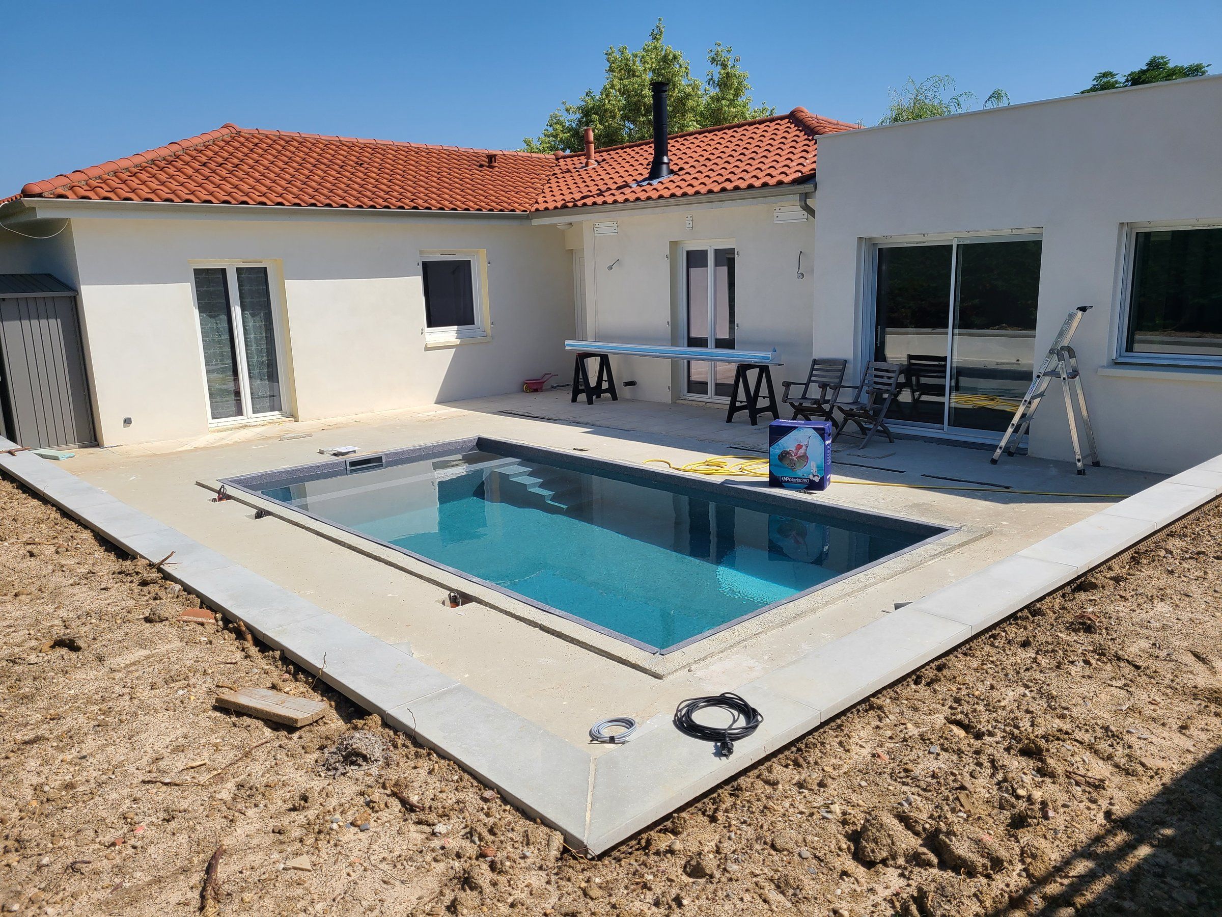 Juillet 2021 — la piscine en eau, margelles posées