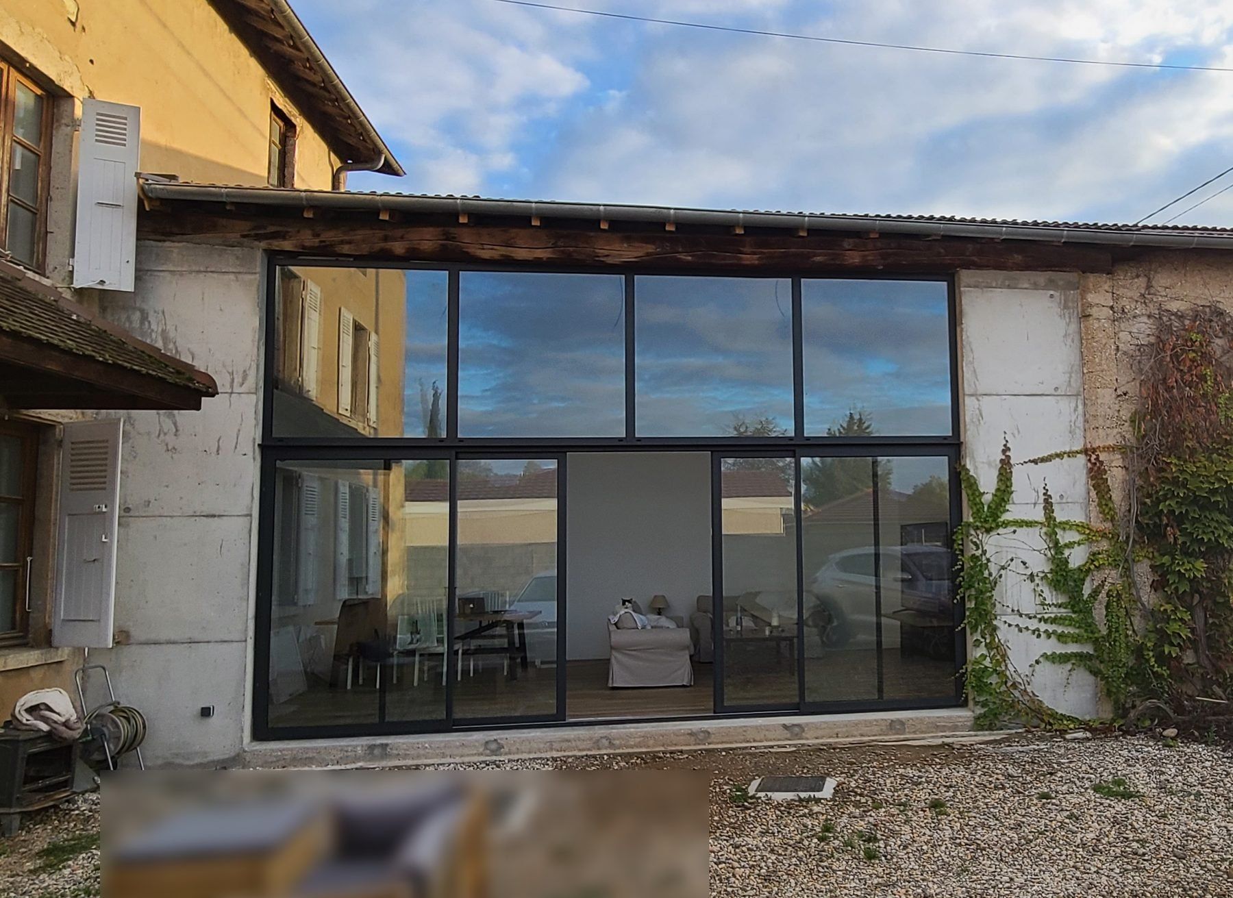 La même travée après travaux, fermée par une baie vitrée sur deux niveaux