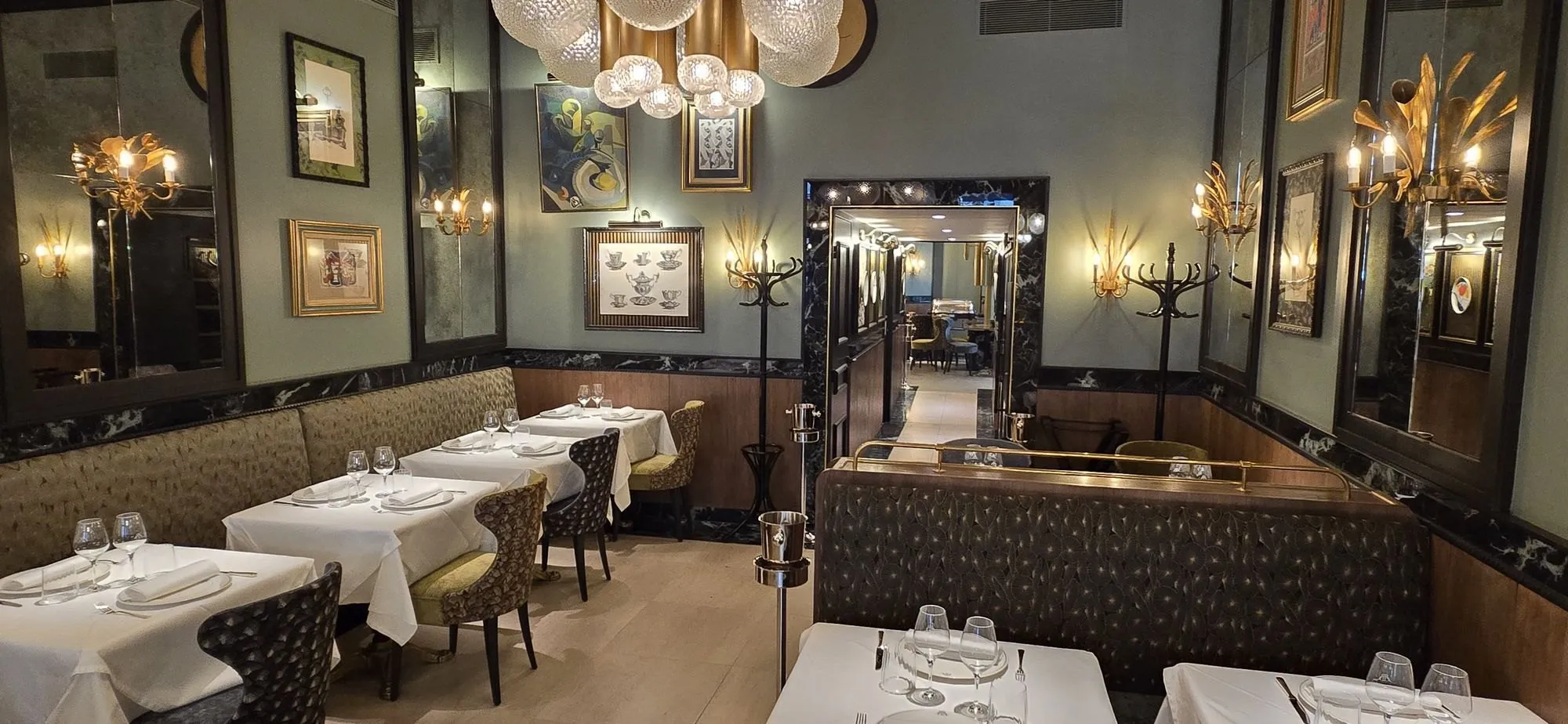 Salle de la brasserie : banquettes, lustres dorés, murs vert d'eau