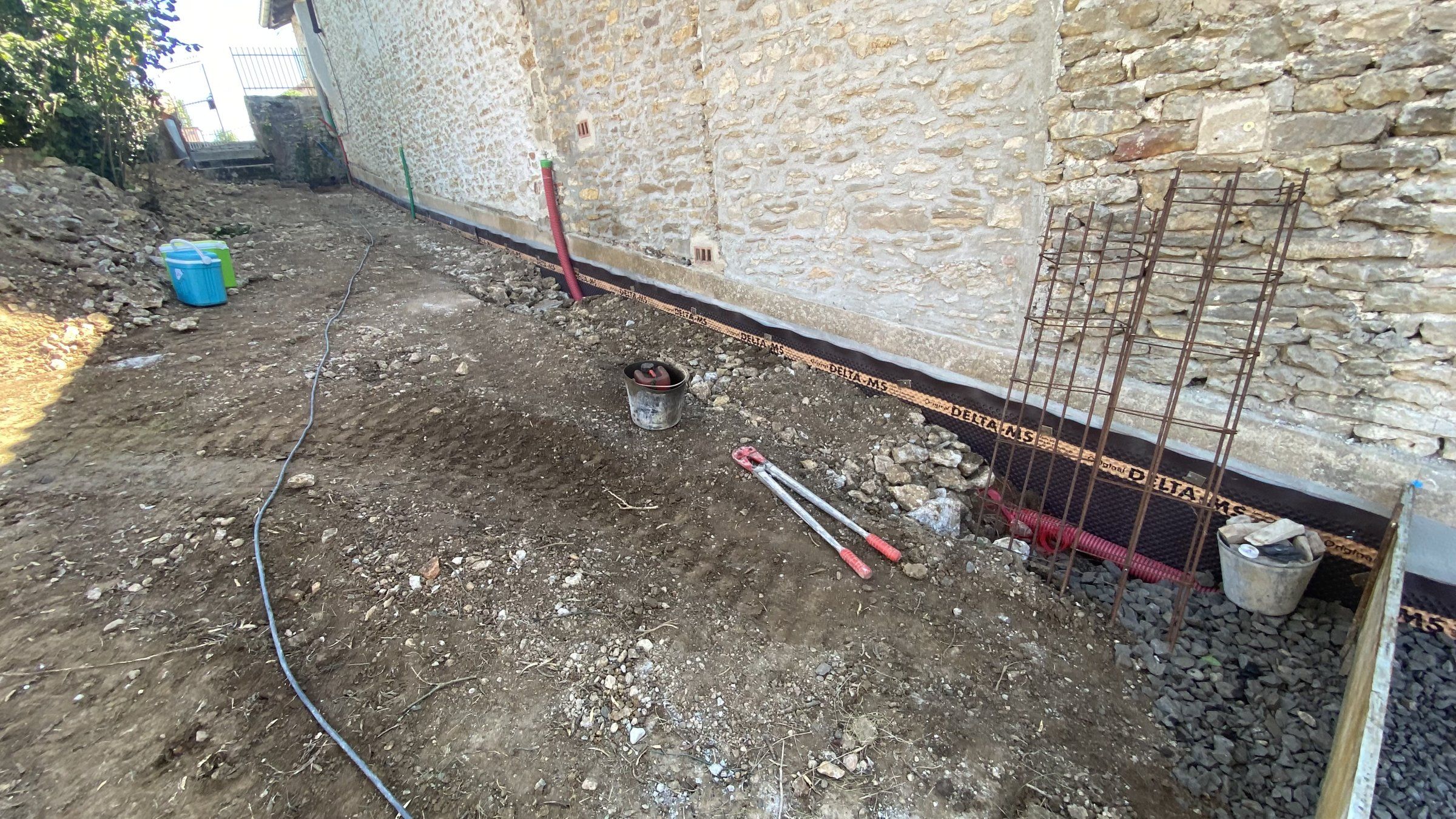 2024 — terrassement et ferraillage le long d'un mur en pierre